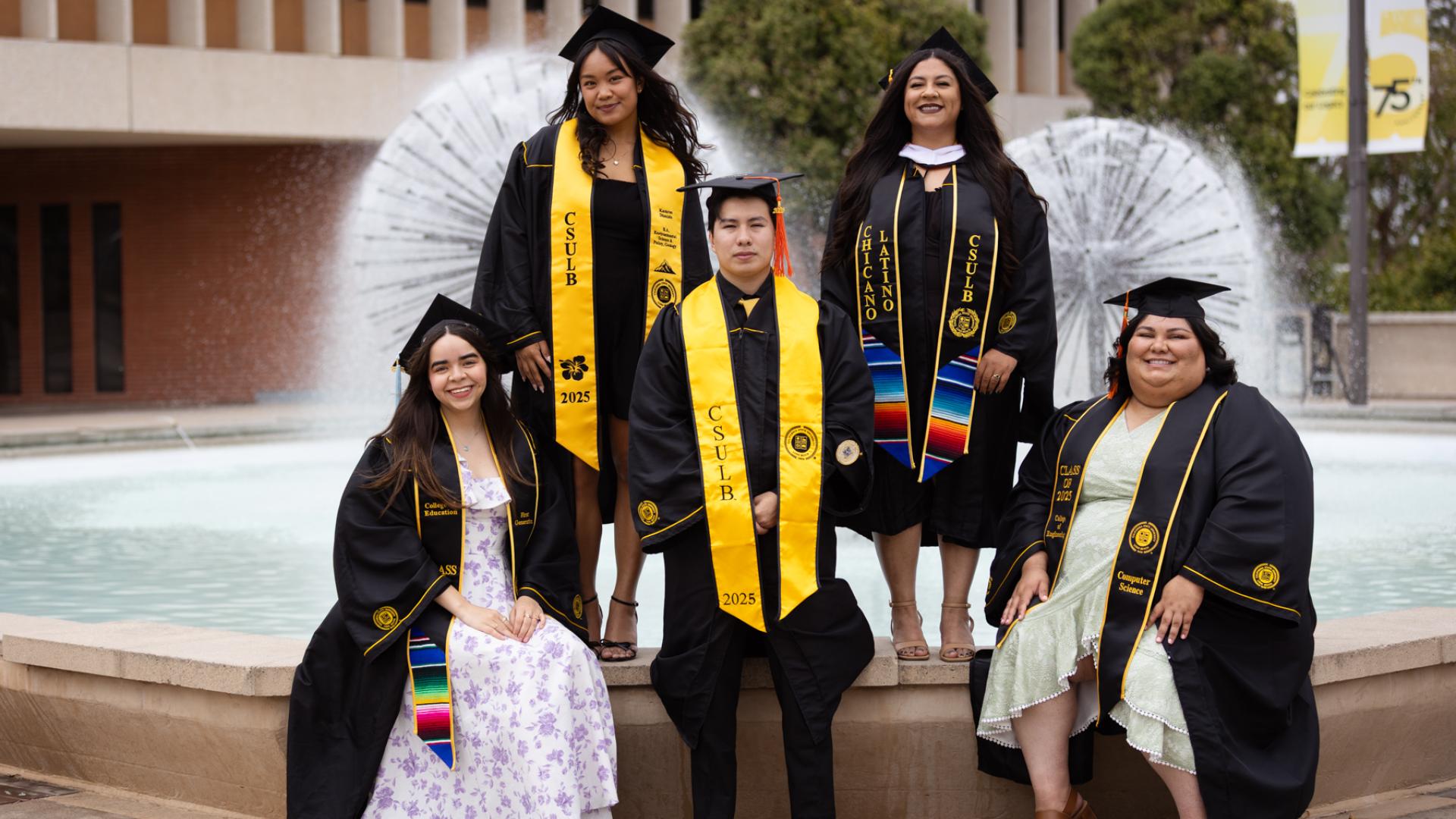 A group of graduating students standing in front of the water fountain at Brotman Hall