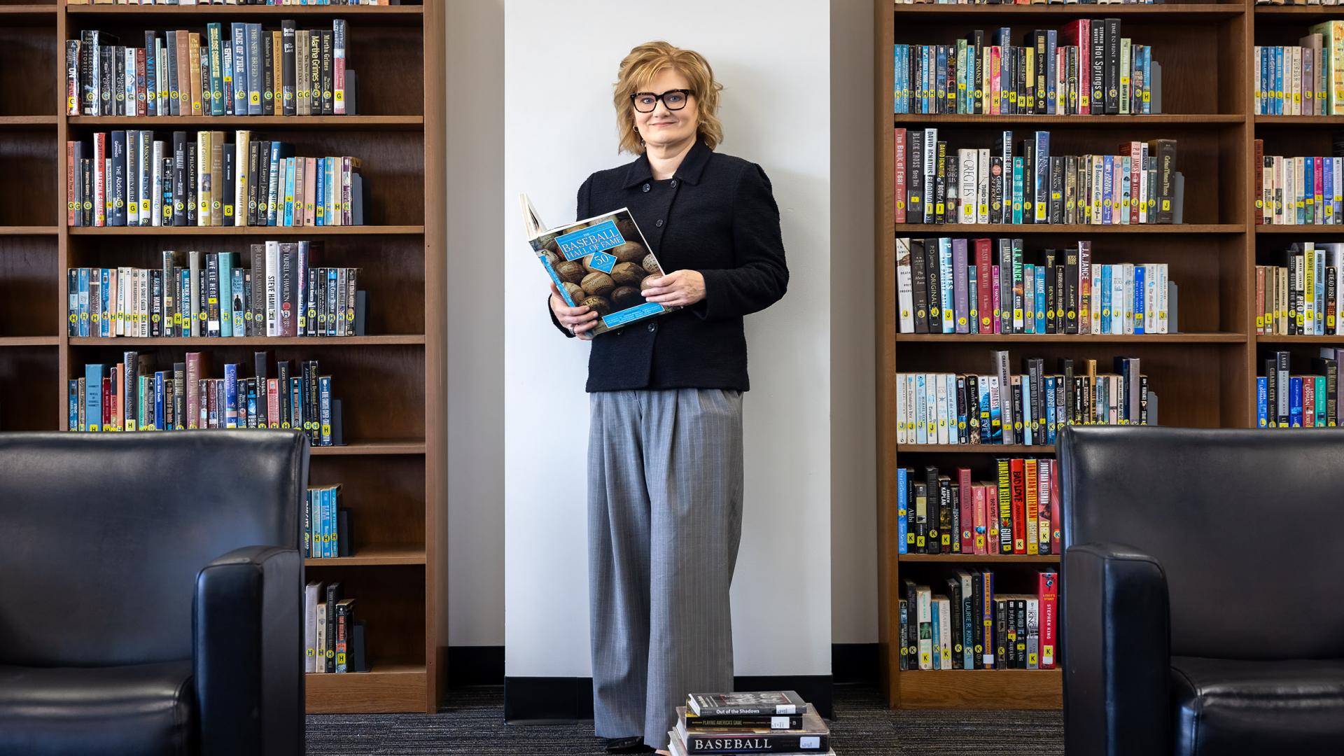 Dean Dill holding a book in the library.