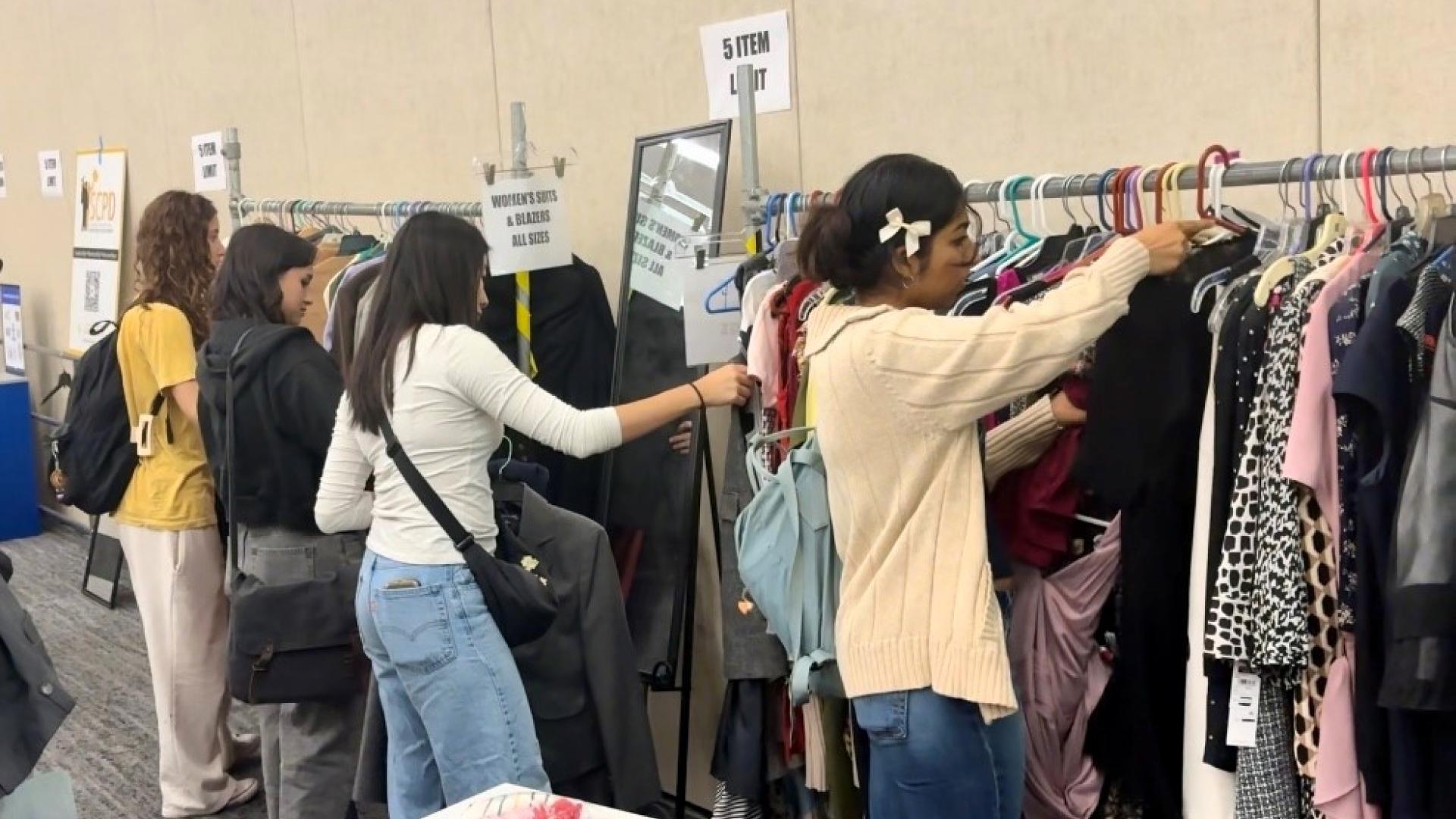 Students looking at clothes on racks