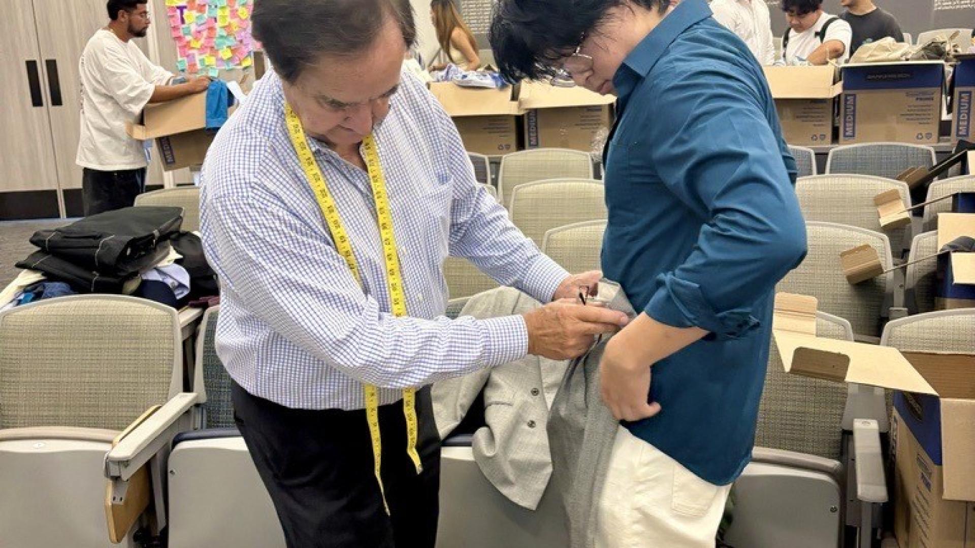 Ken Miller helping student with clothes at COB Closet 2025