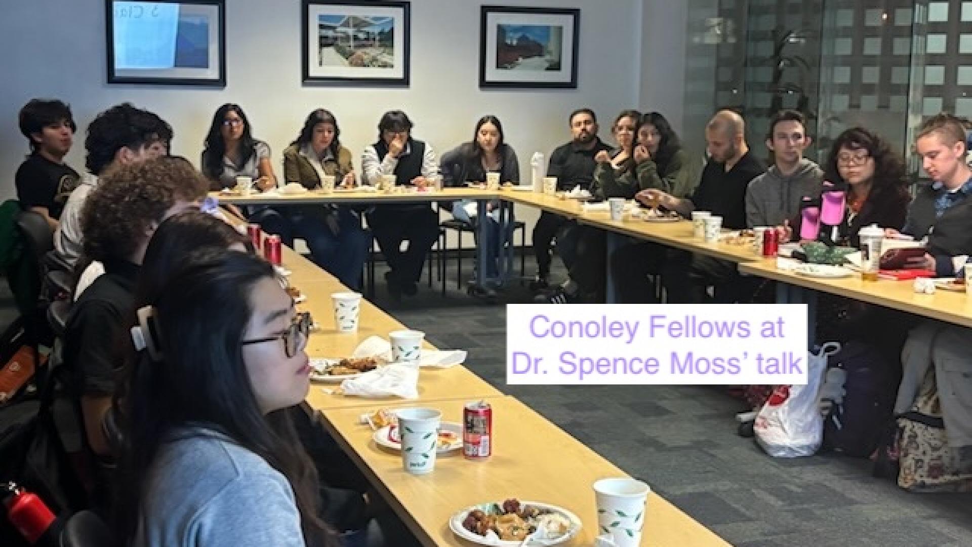 people sitting around a horseshoe shaped table