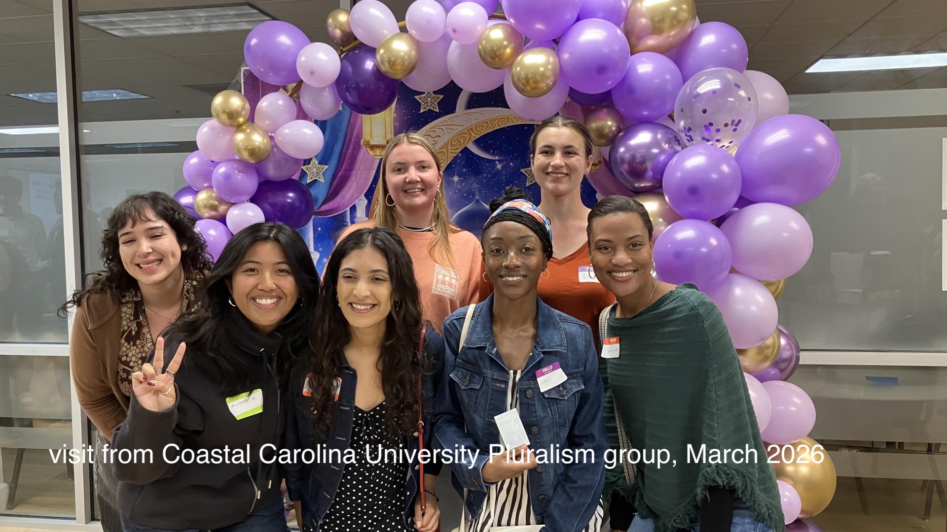 group of people standing in front of balloons