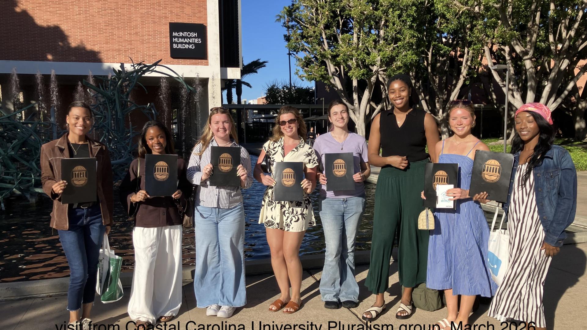 students standing in line holding folders