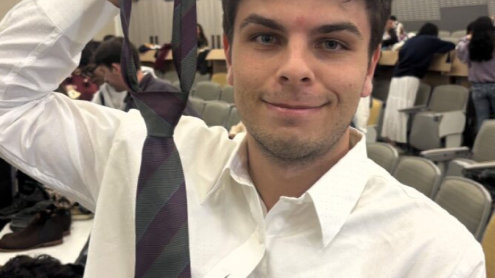 A student showing how to tie a neck tie