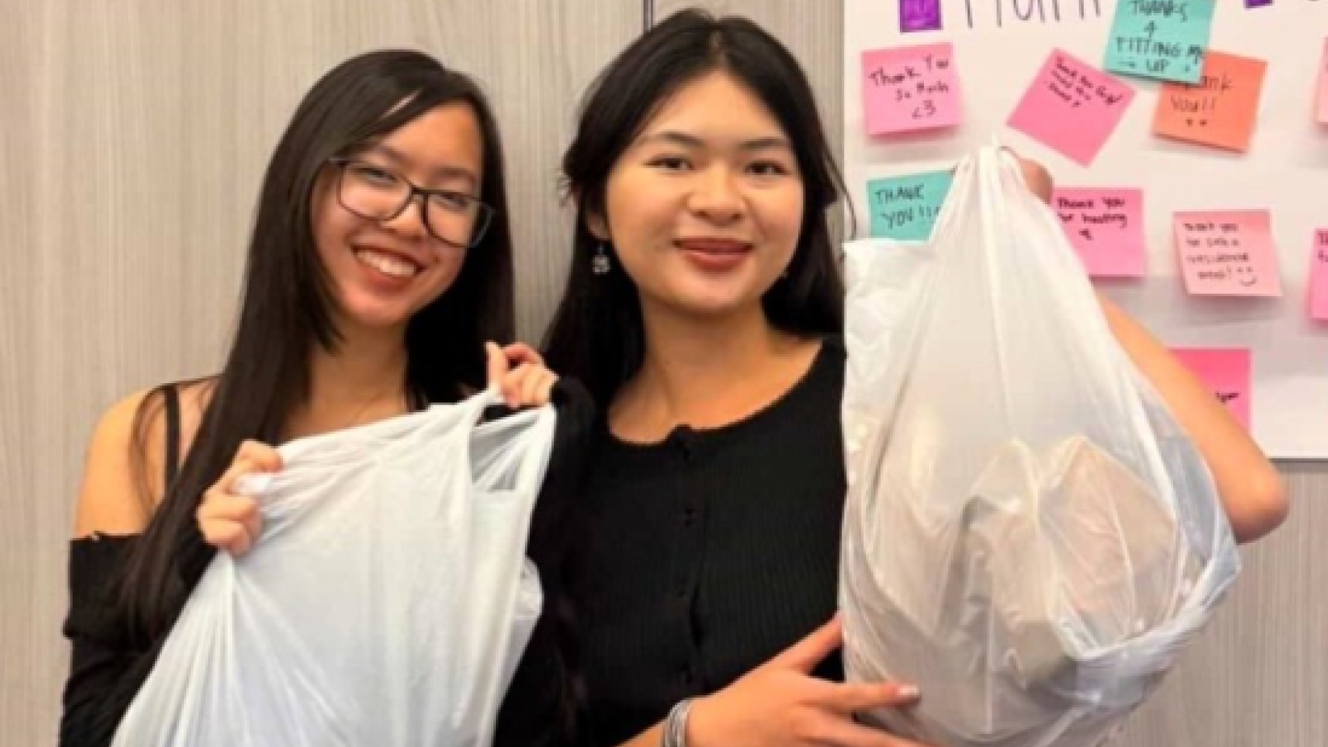 Two girl students with bags of clothes