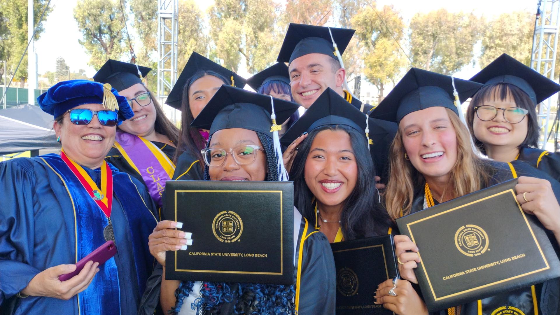 professor and graduates in regalia