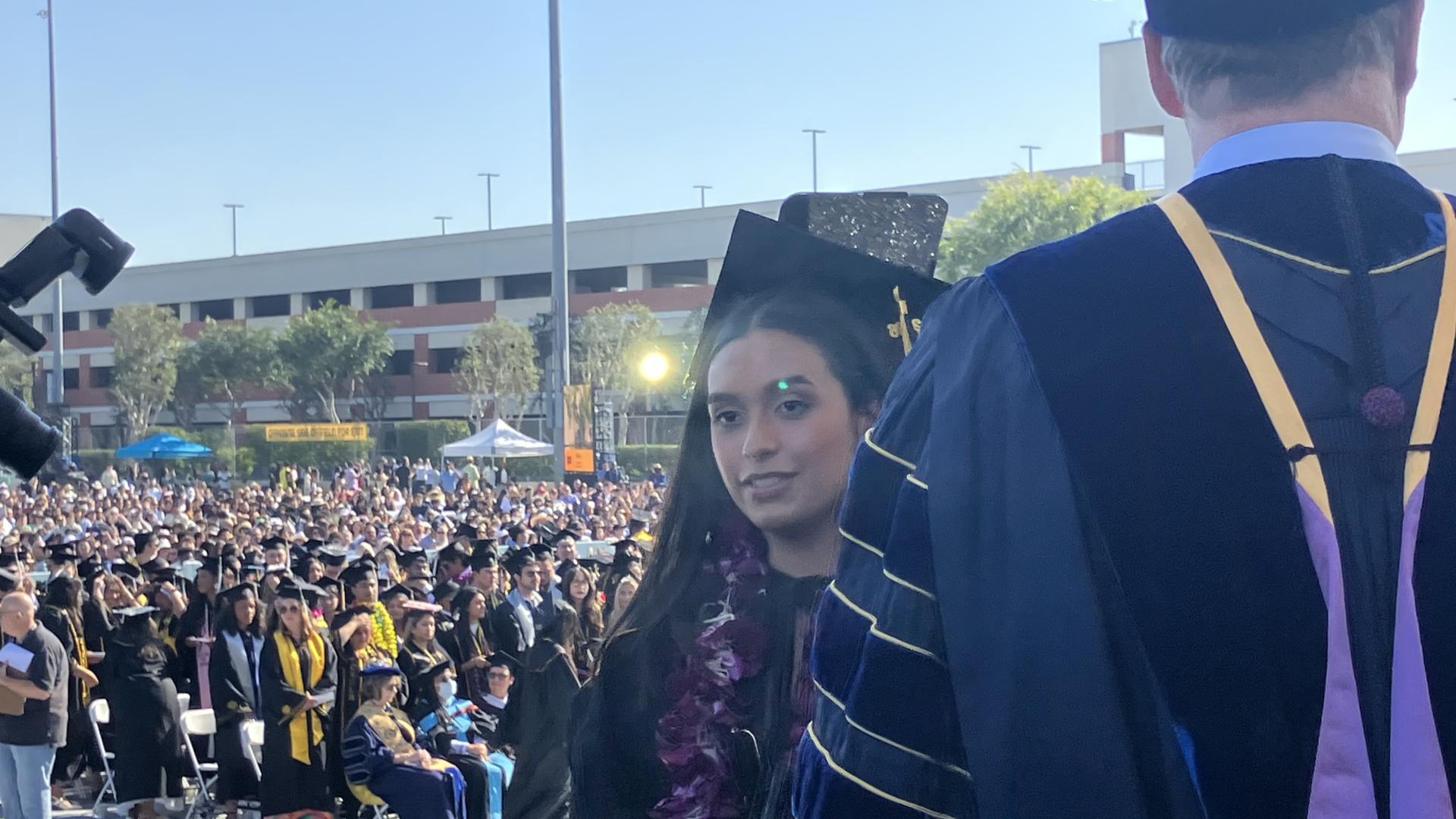 student crossing stage at graduation