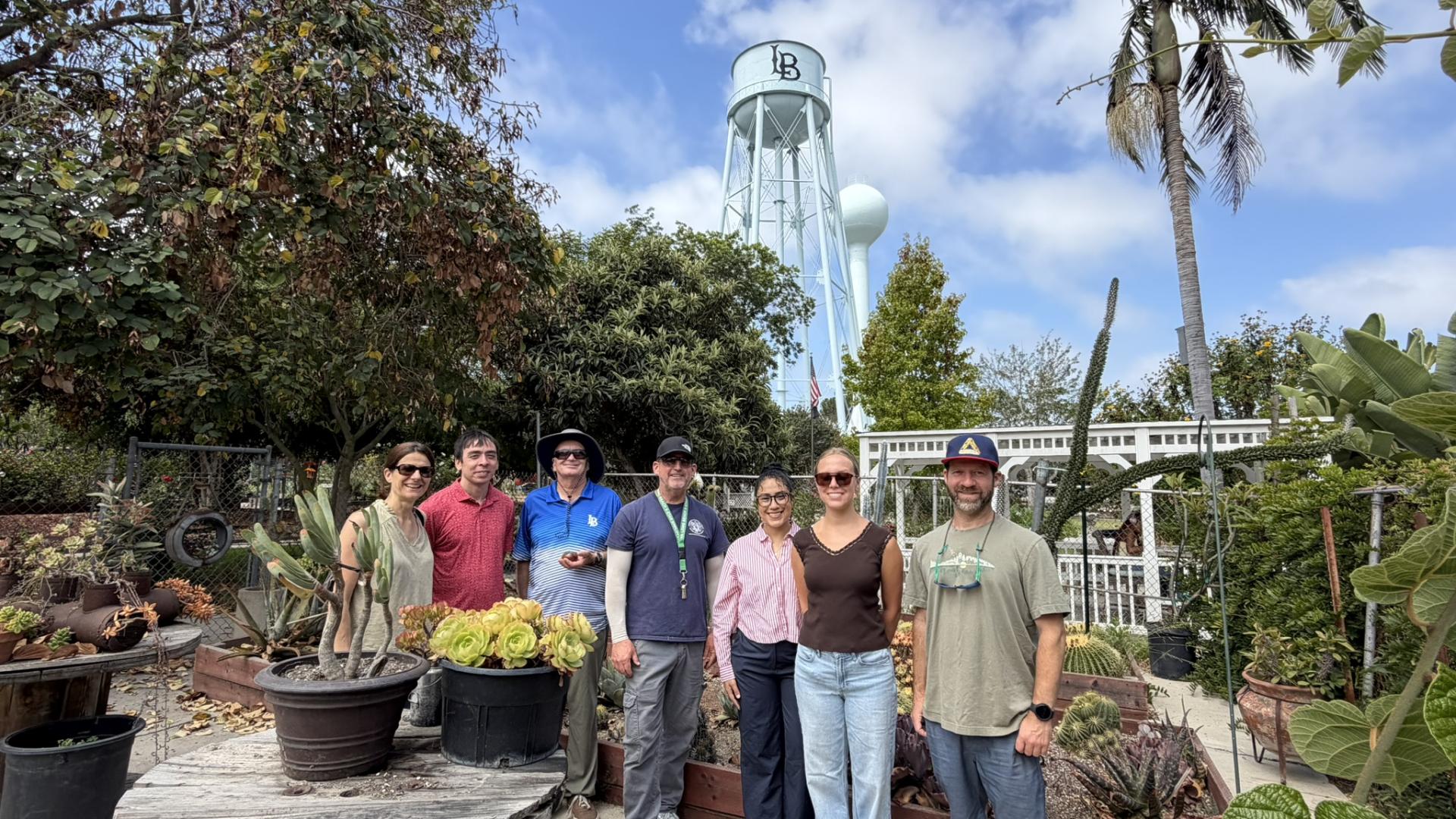 A group of people standing in front of a garden