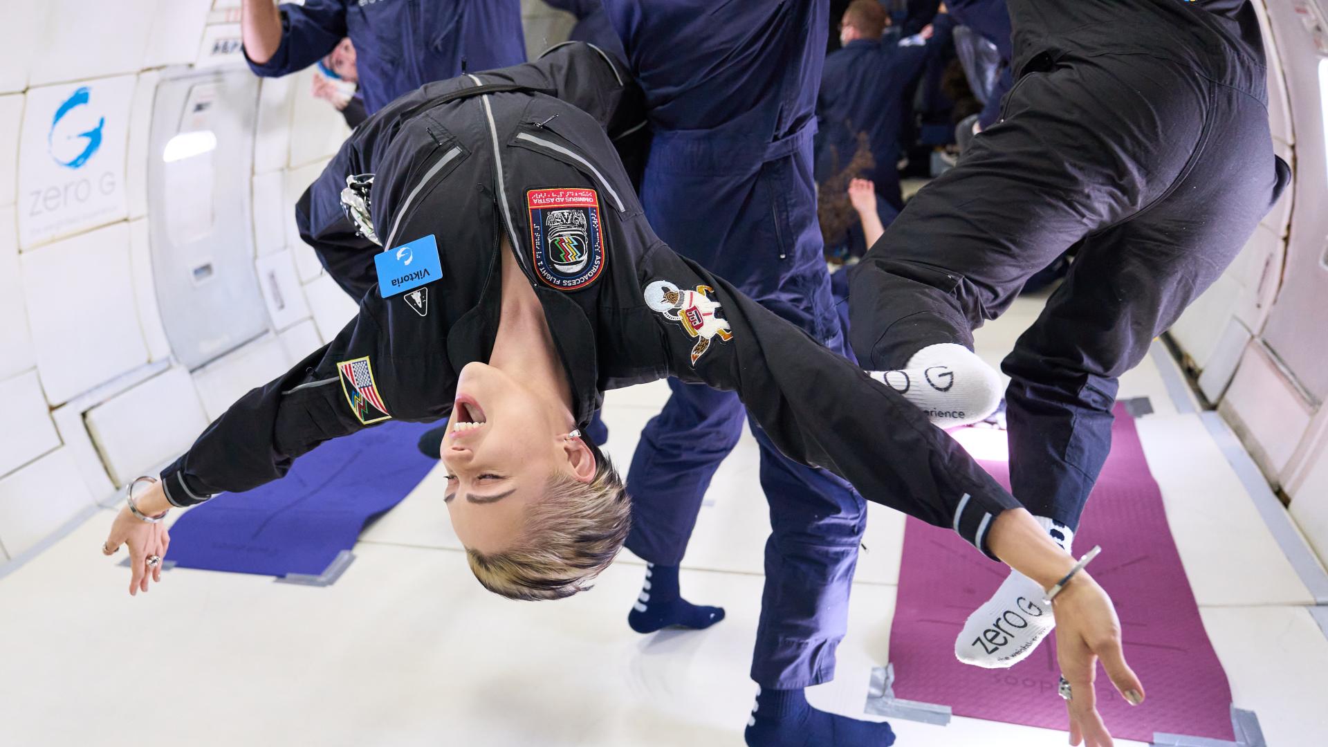 Female space crew member flies upside down (Photo: AstroAccess)