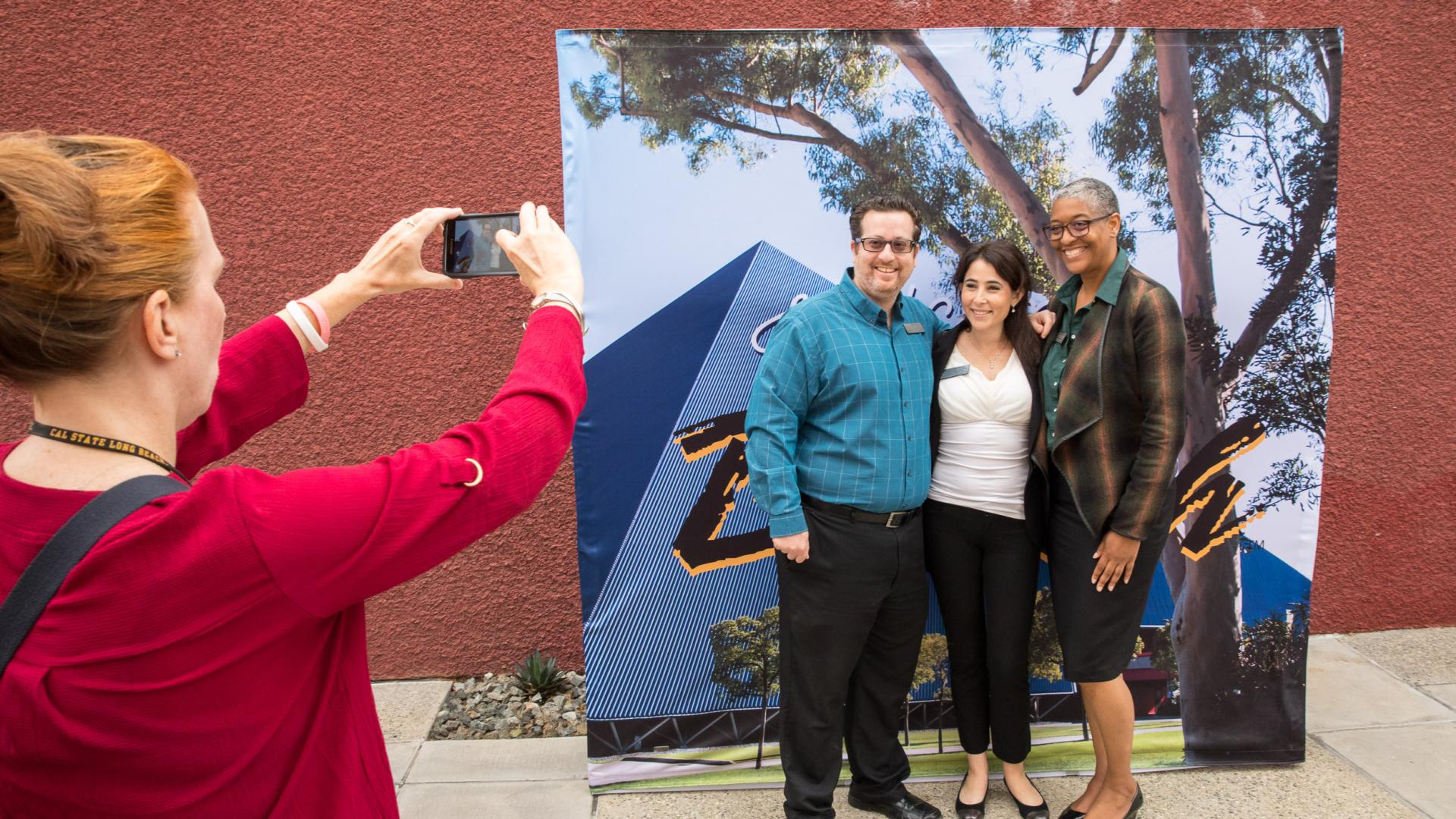 Guests take pictures in front of Pyramid banner
