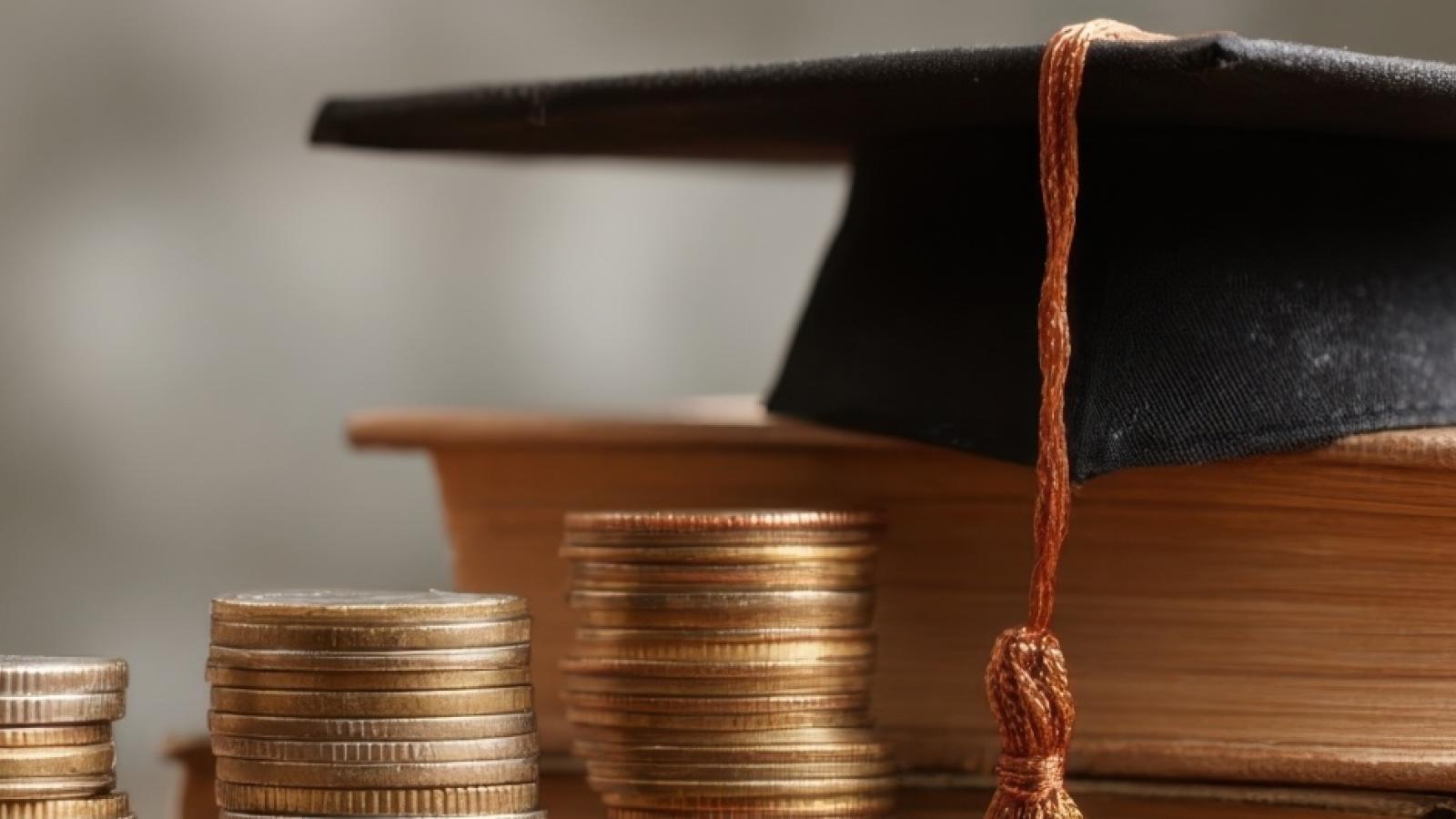Stock image of graduation cap with books and money