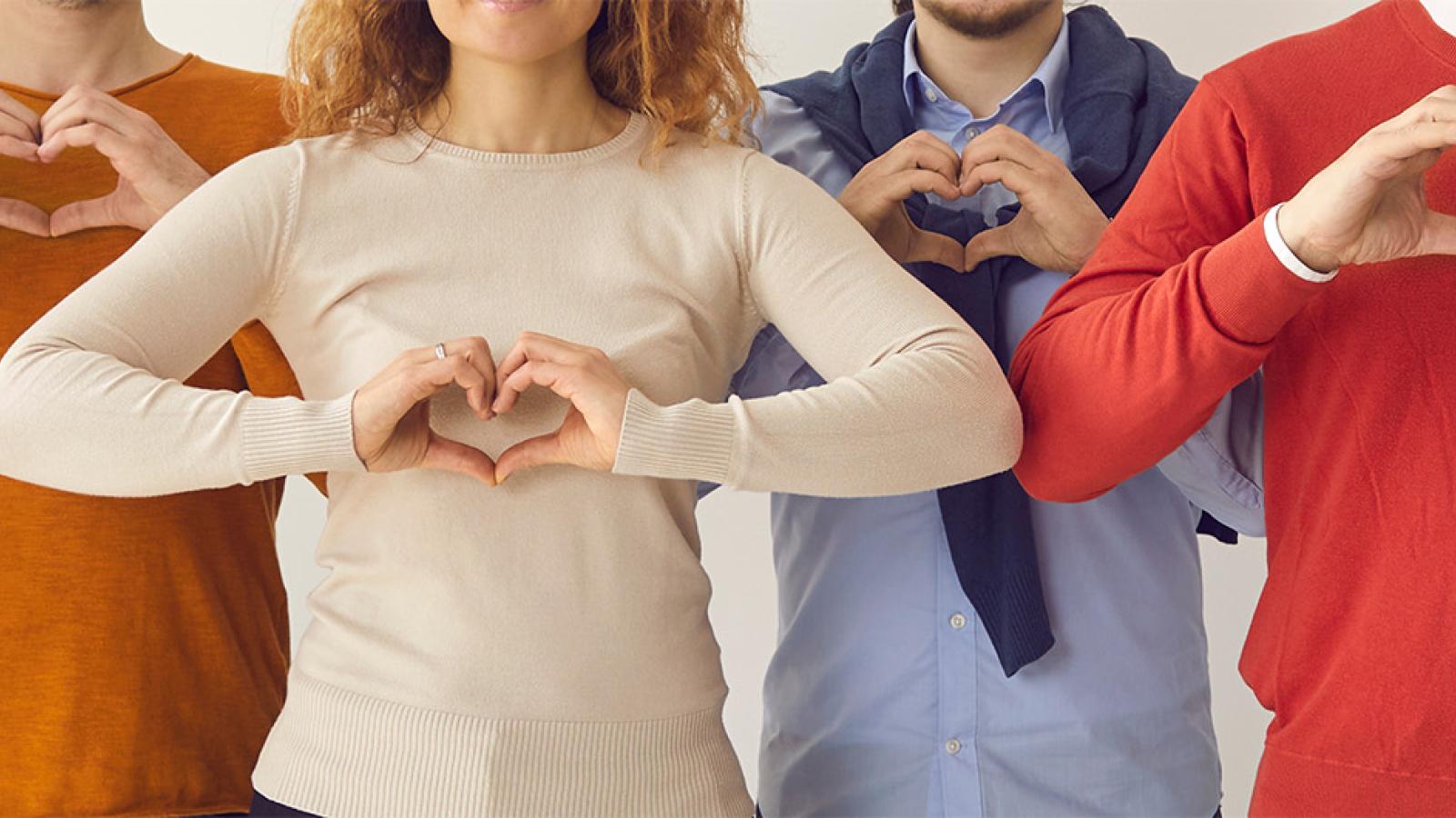 group of people making heart shapes with their hands