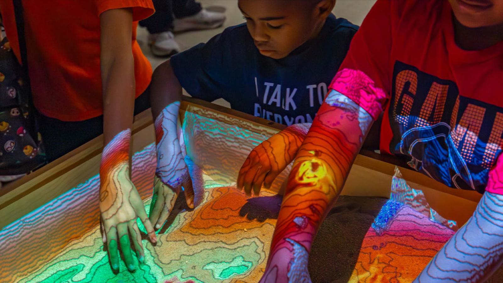 kids interacting with augmented reality sandbox