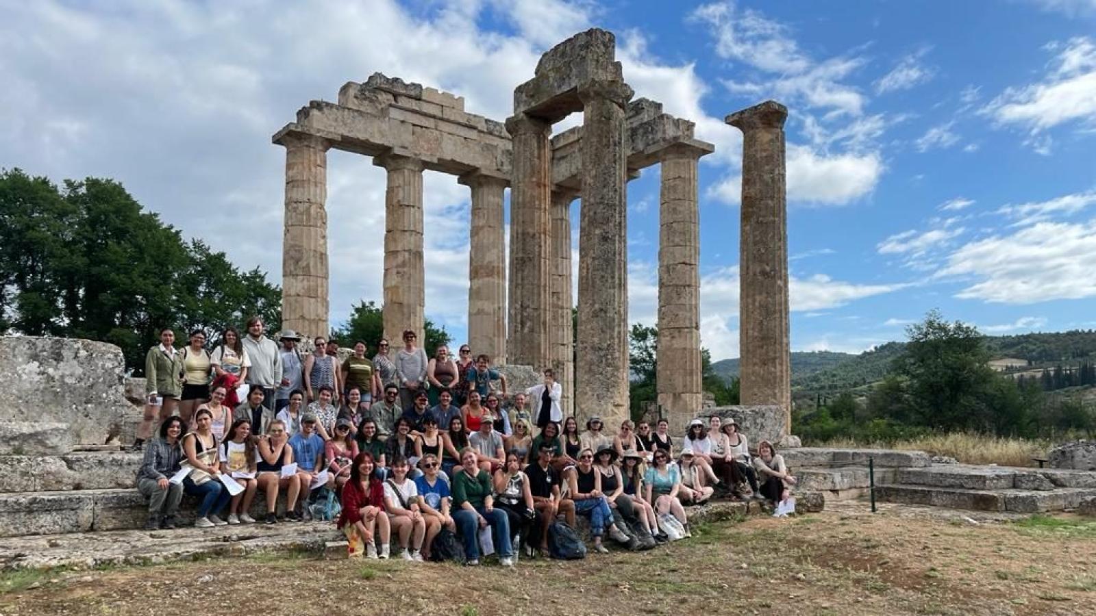archaeologists posing before an ancient ruin