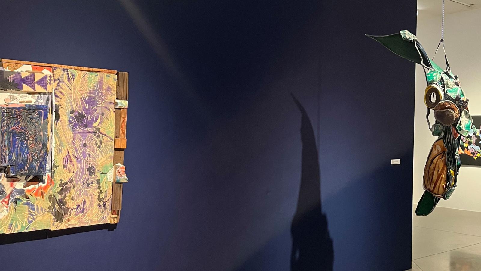 pieces of art in front of a navy blue wall