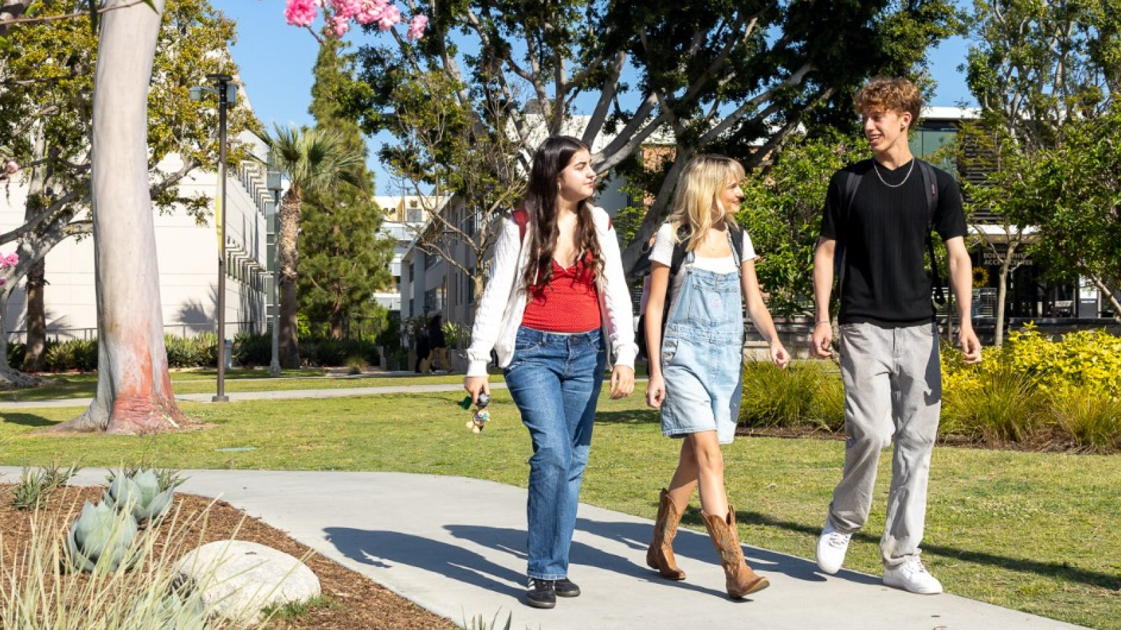 Image of three students walking on campus.