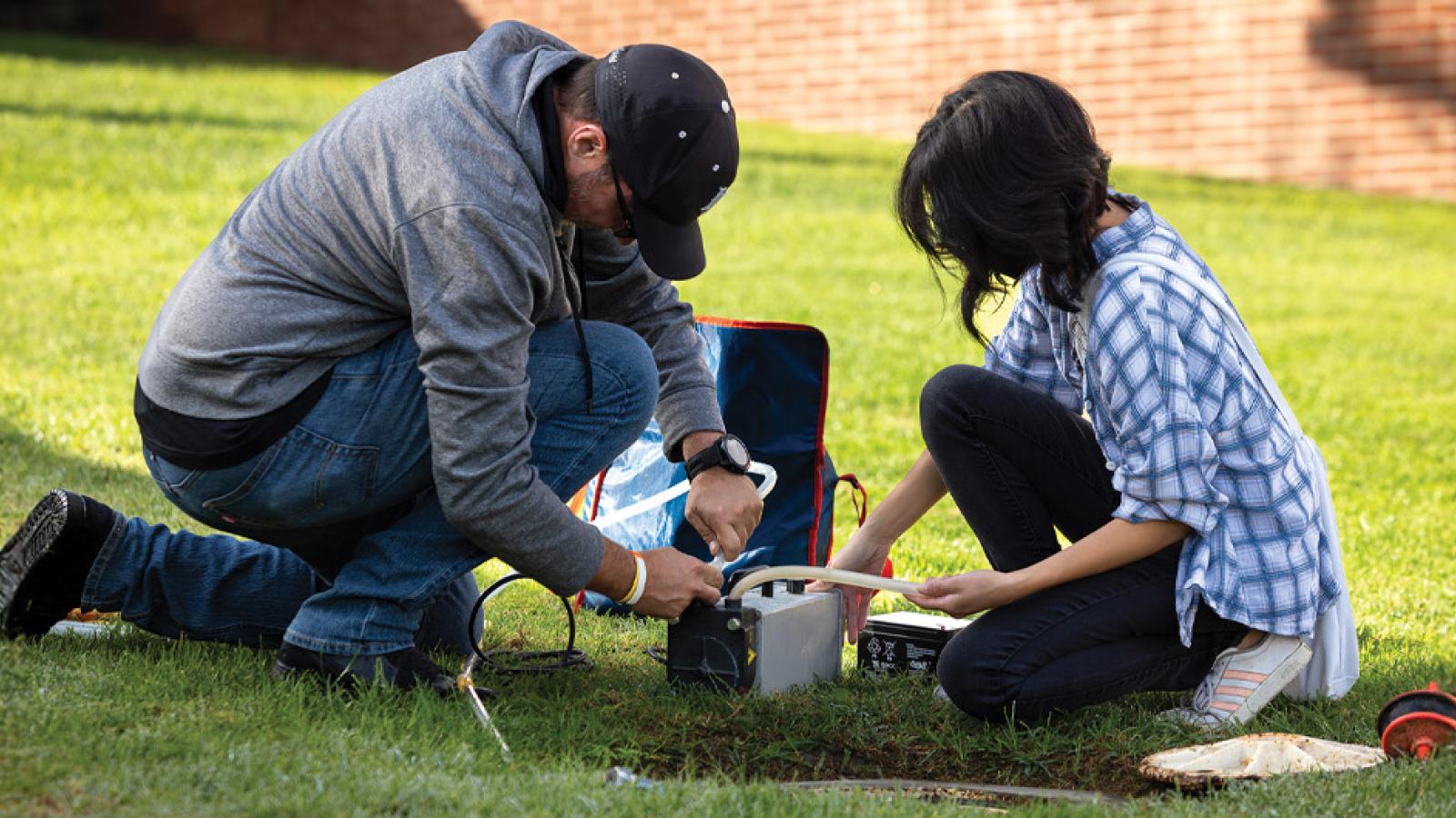 Ben Hagedorn and student researcher taking groundwater samples