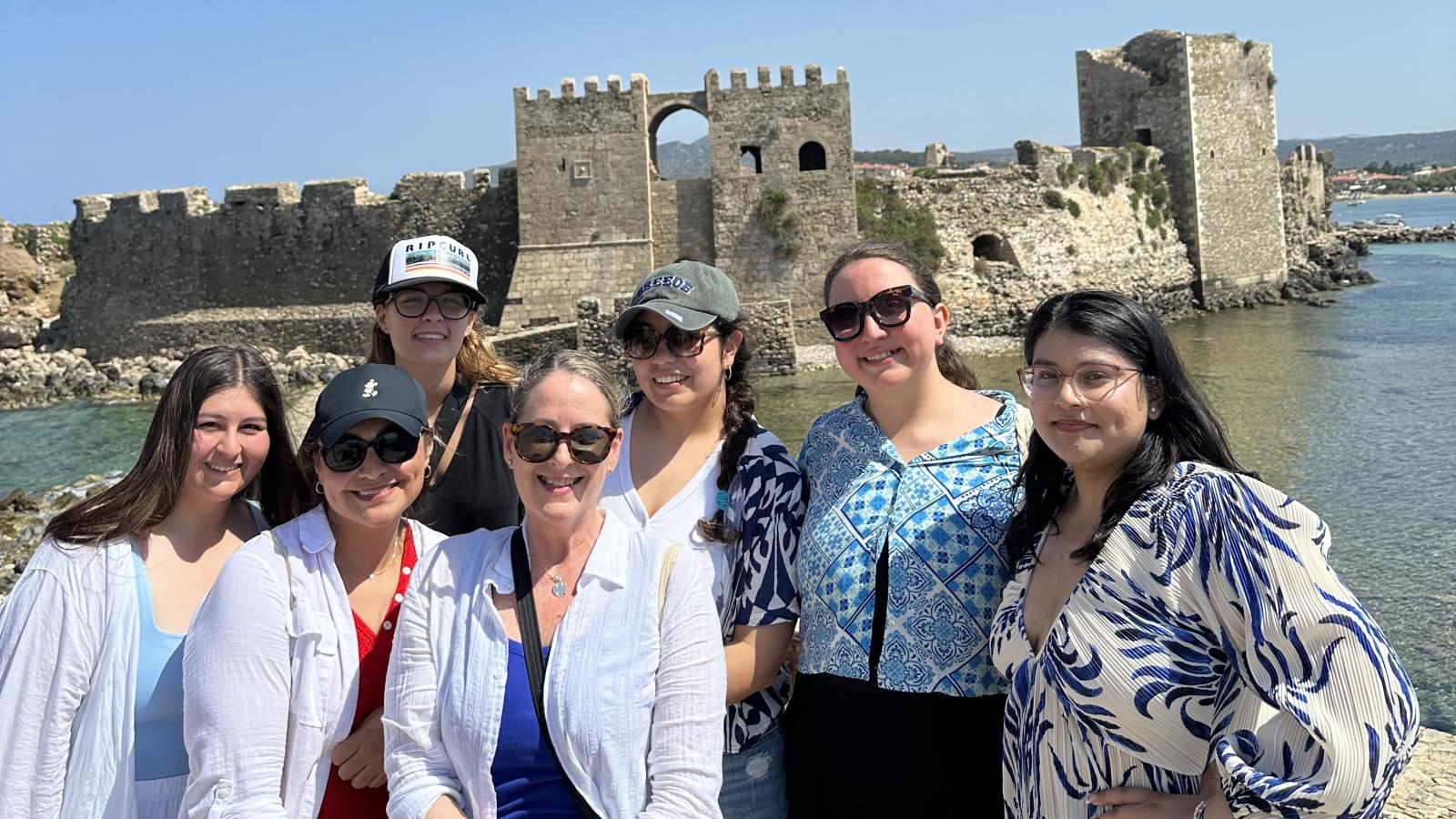 people in front of medieval castle by water