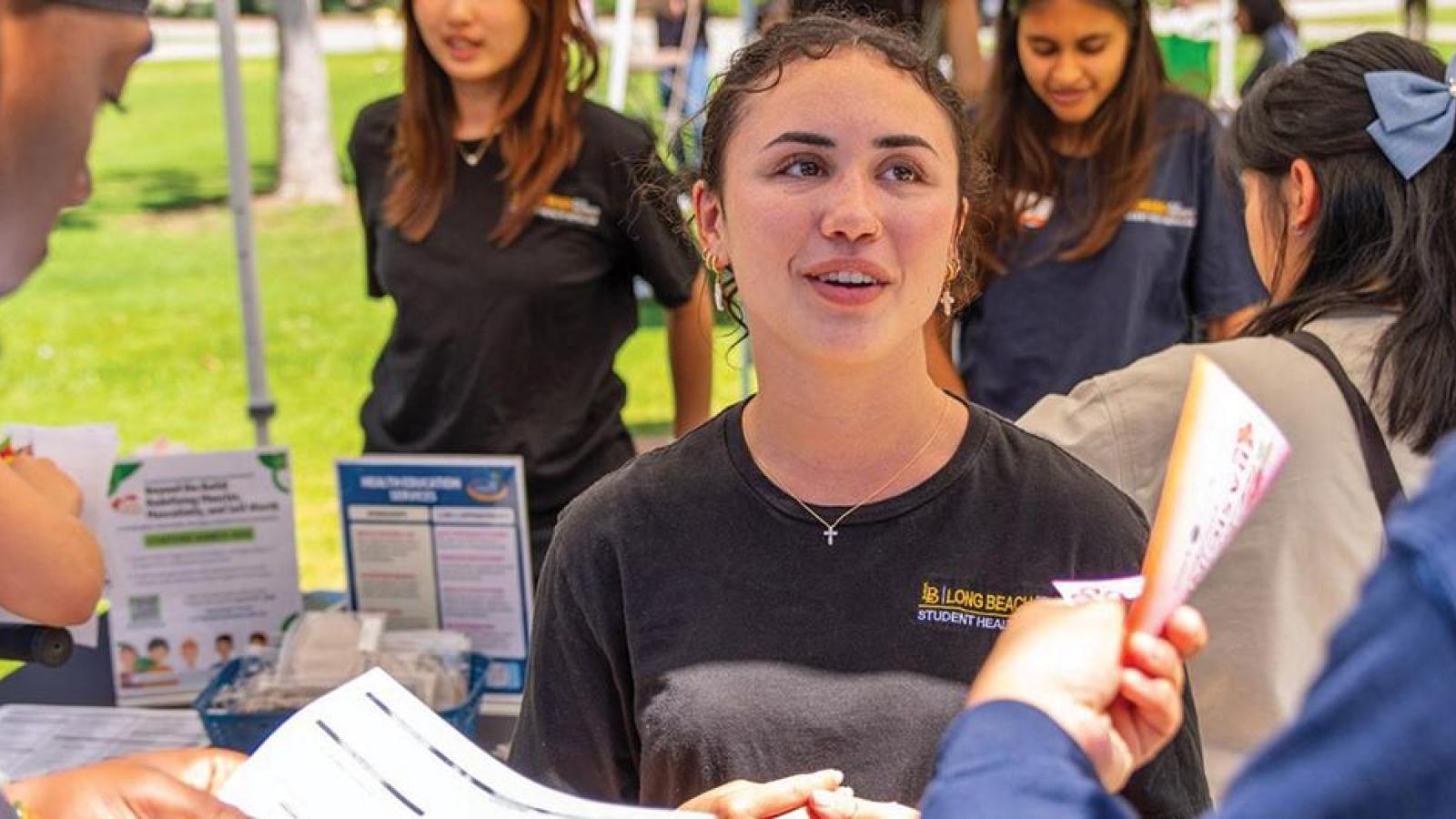 Students receiving information at an on-campus boothing event.