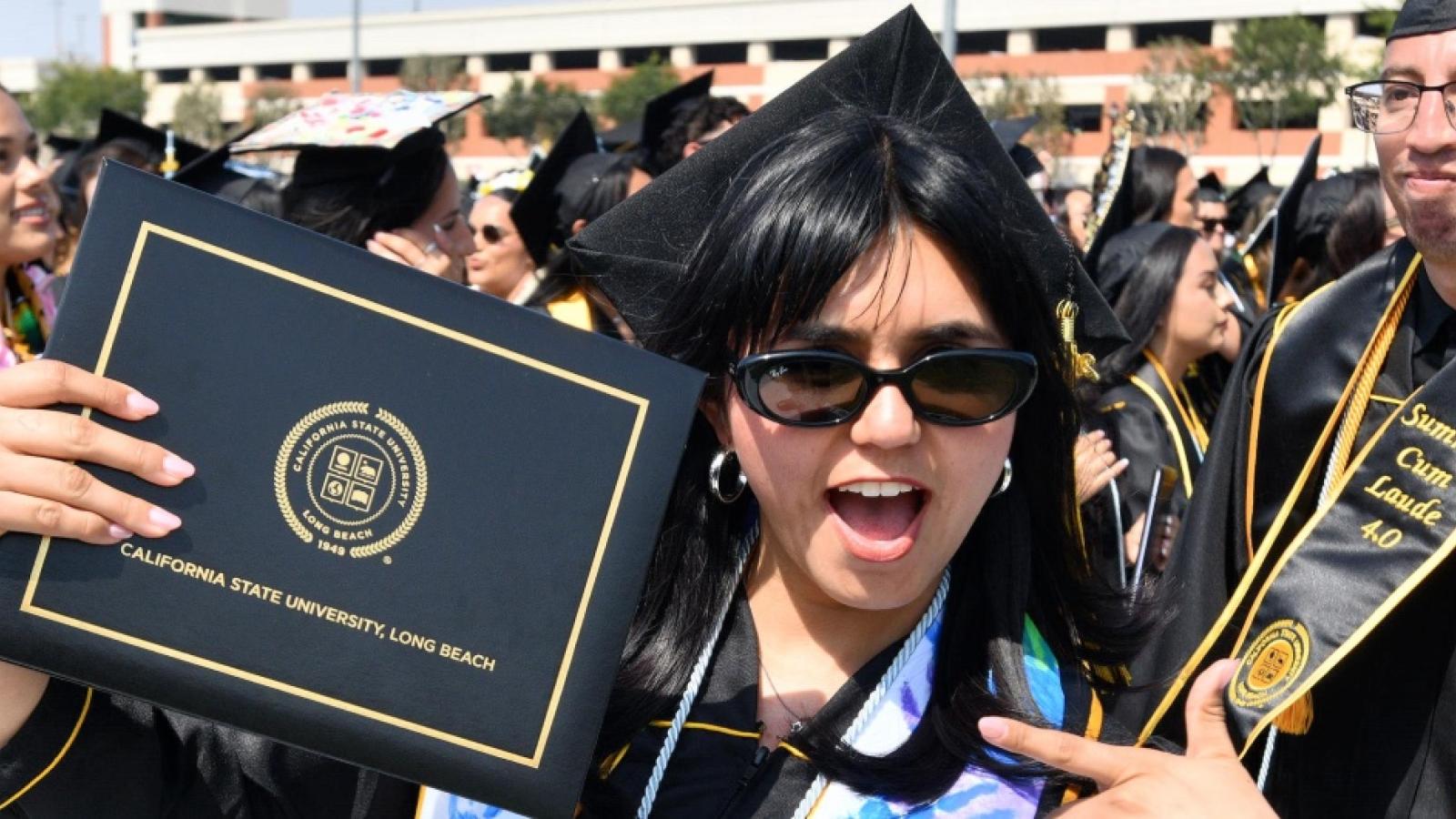 Graduate holds up her diploma