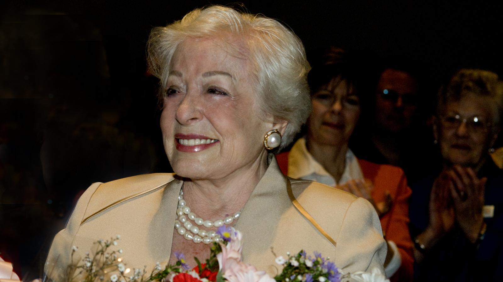 Smiling Regena Cole holding flowers