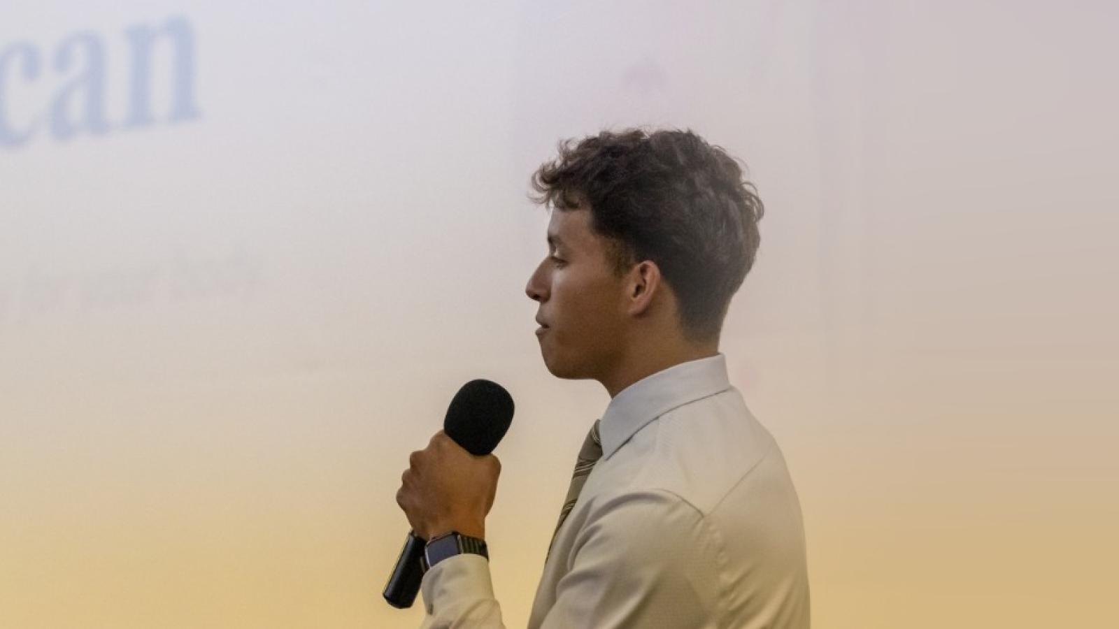 man presenting on stage in front of a screen