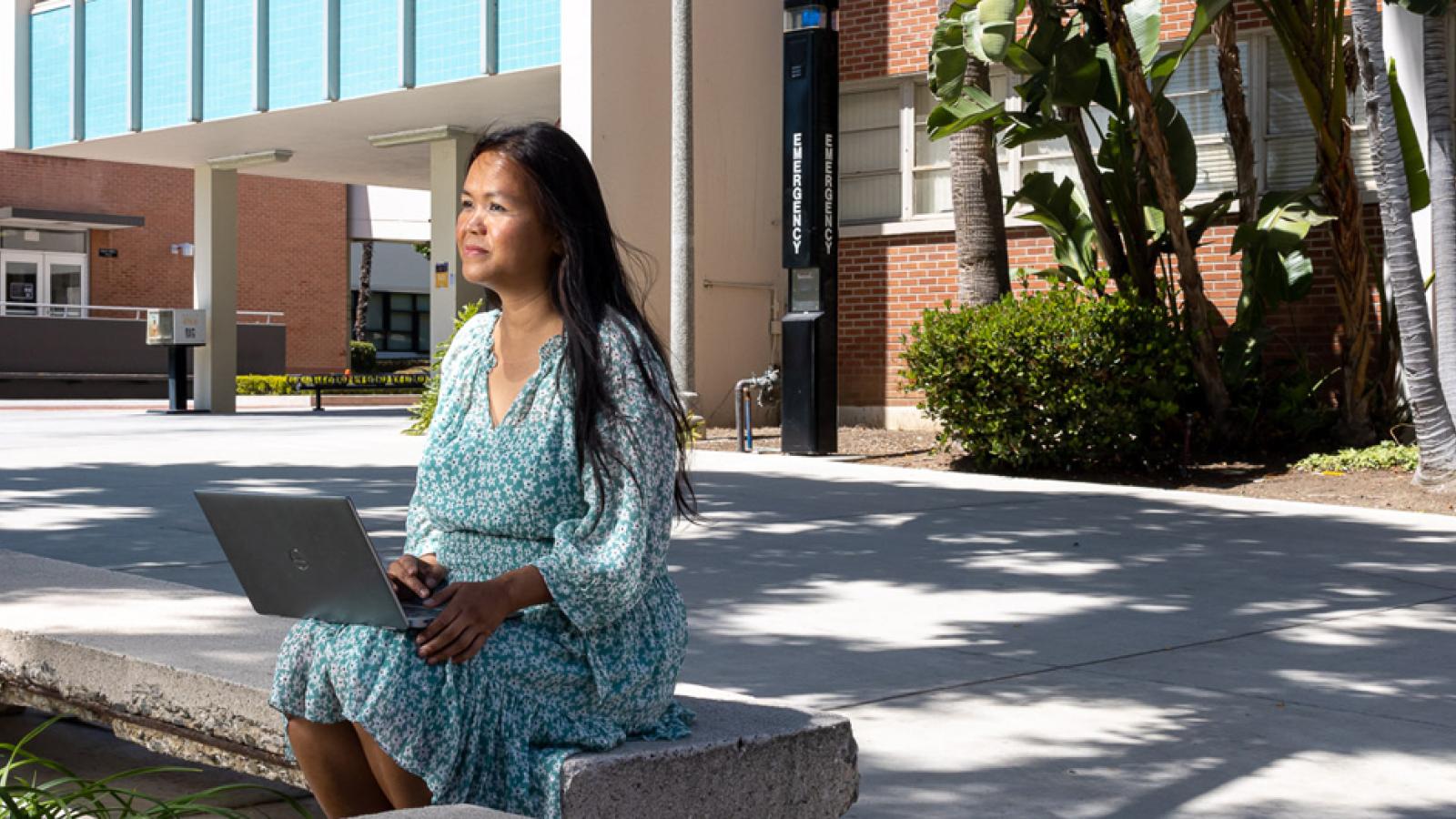 Professor Sophia Seng sitting outside on campus