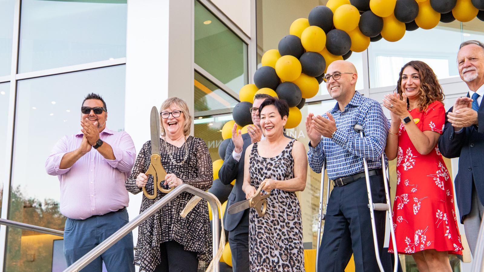 Anna Ngai, Jane Close Conoley and others cut ribbon at Alumni Center