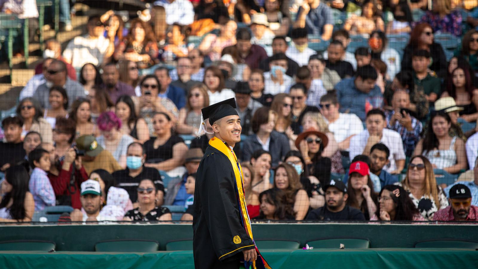 Graduate walks past crowd at Commencement