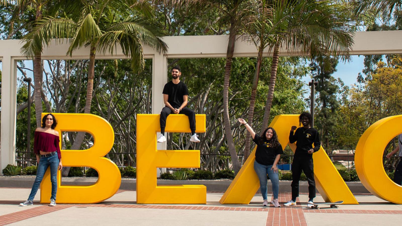 students posing next to the Go Beach sign