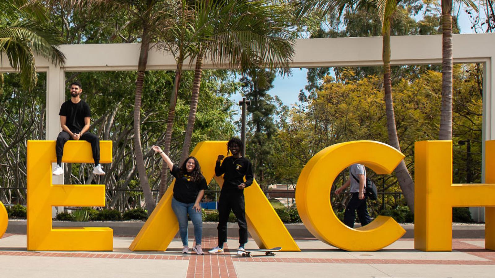 students posing next to the Go Beach sign