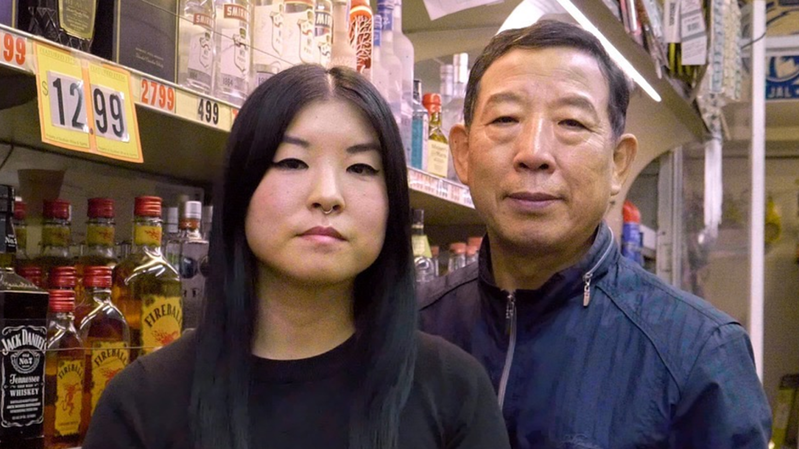 Two people standing in a liquor store by shelfs of alcohol