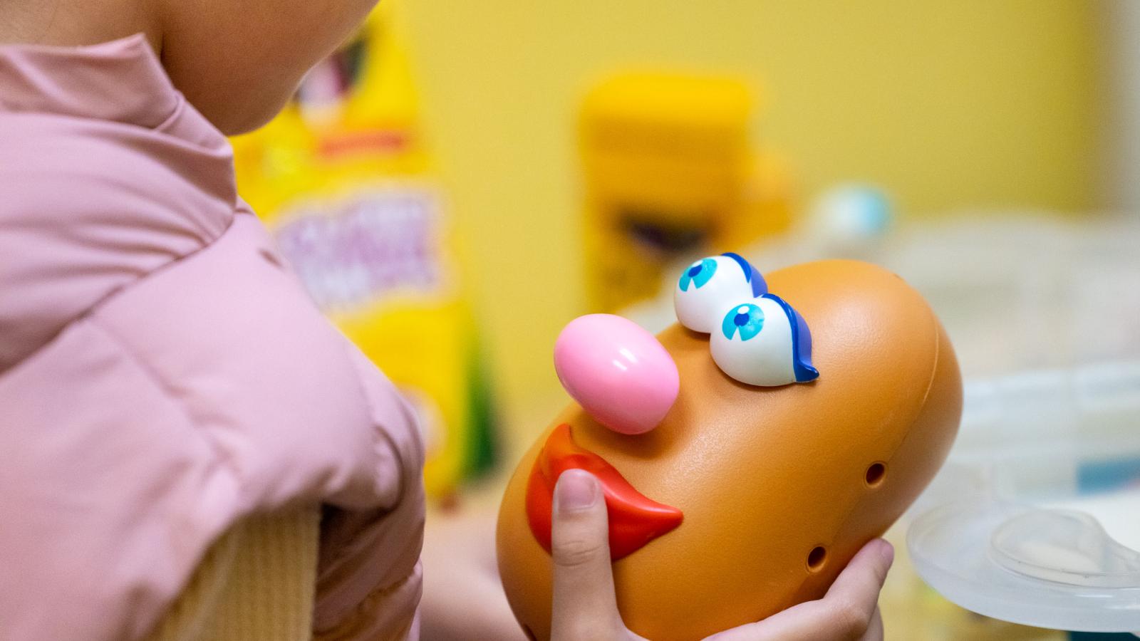 Child playing with Mr. Potato Head