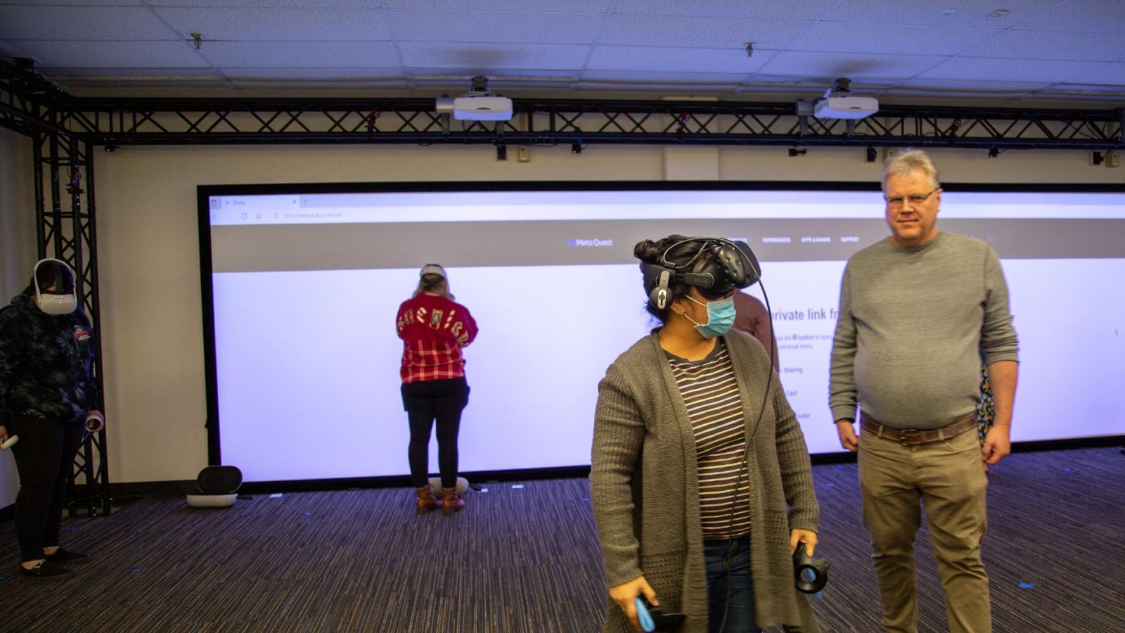 Stephen Adams poses with people using VR technology