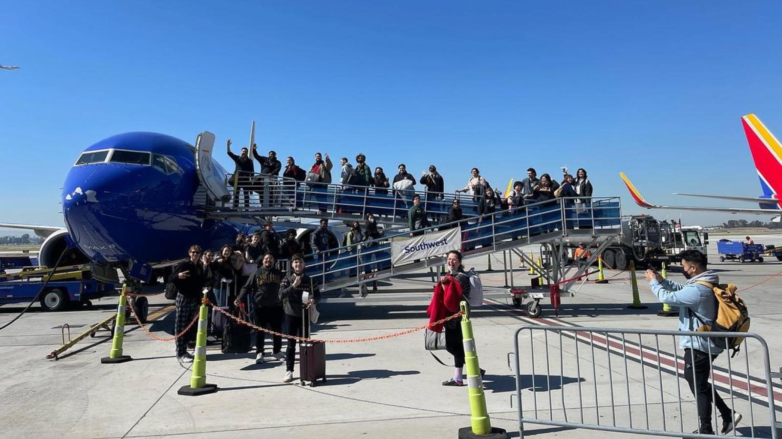 Chamber Choir Members Boarding a Plane and posing along the stairs leading to the jet door