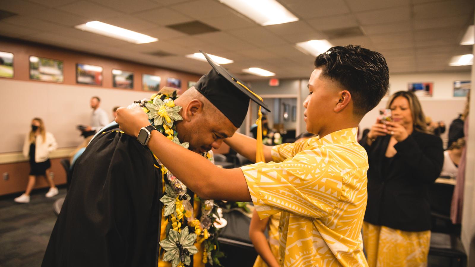 A child hoods a master's in educational administration grad