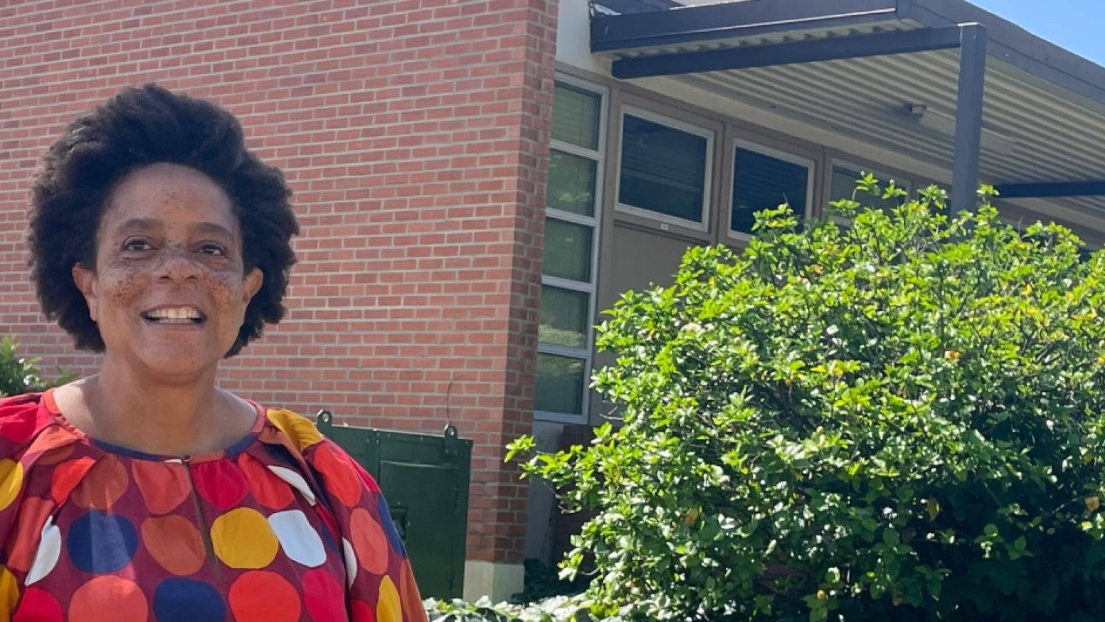A person standing in front of a building smiling