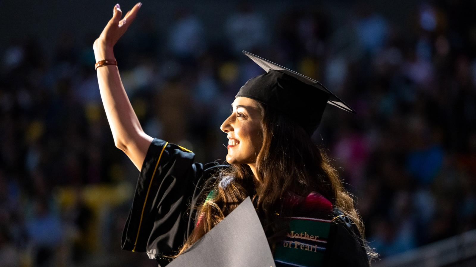 Recent graduate waving