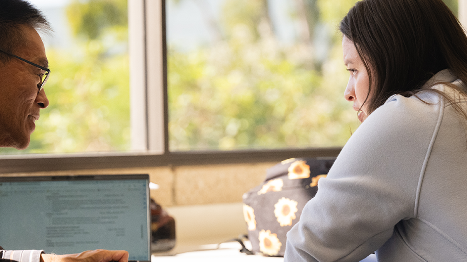 Student receiving guidance on resume writing from a counselor