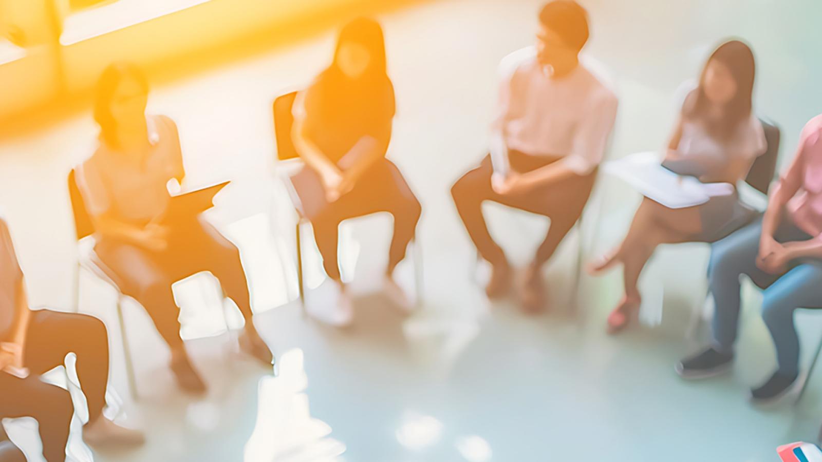 A group of people sitting in chairs arranged in an arc.