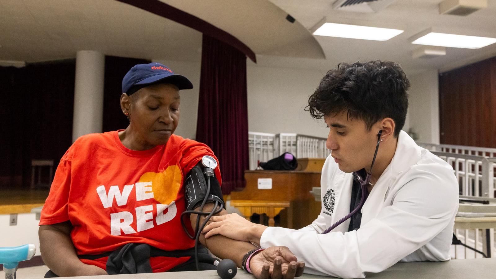 CSULB Nursing student gives blood pressure to community senior