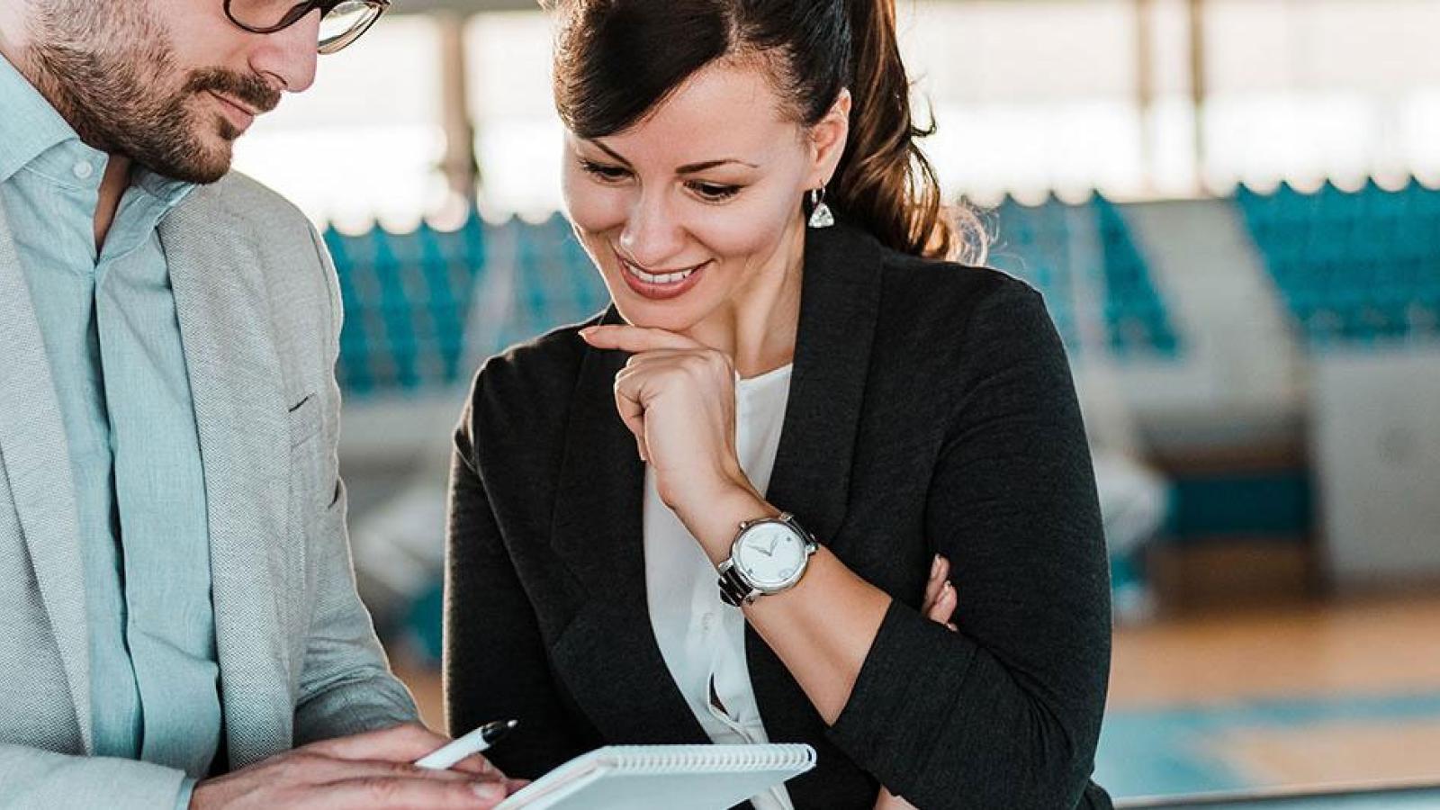 Two people talking in a sports arena