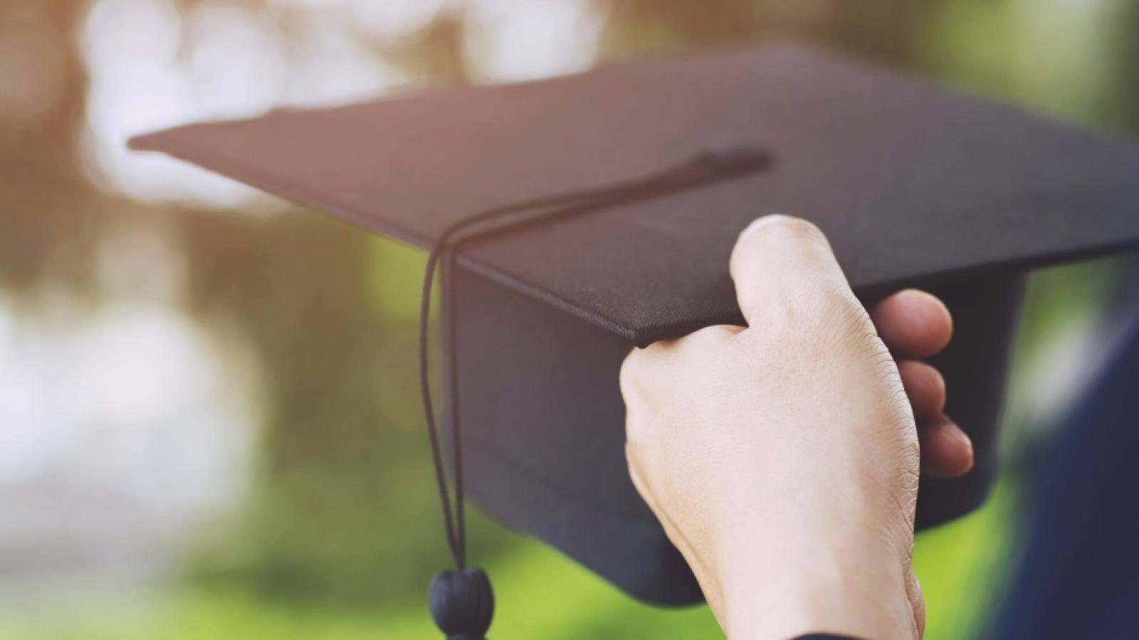 Student hold hats in hand during commencement success graduates 