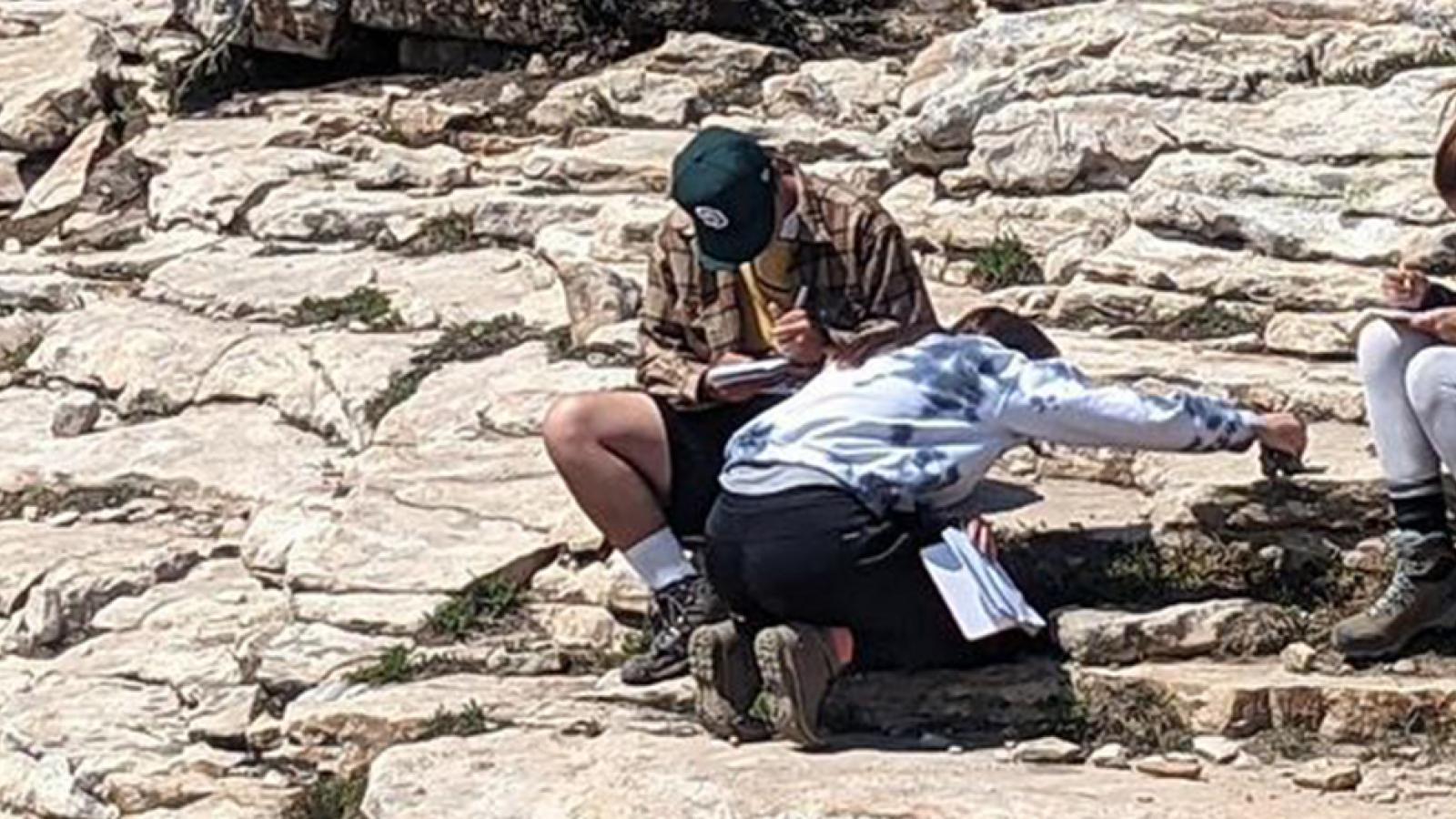 geology students studying rock formations in the field