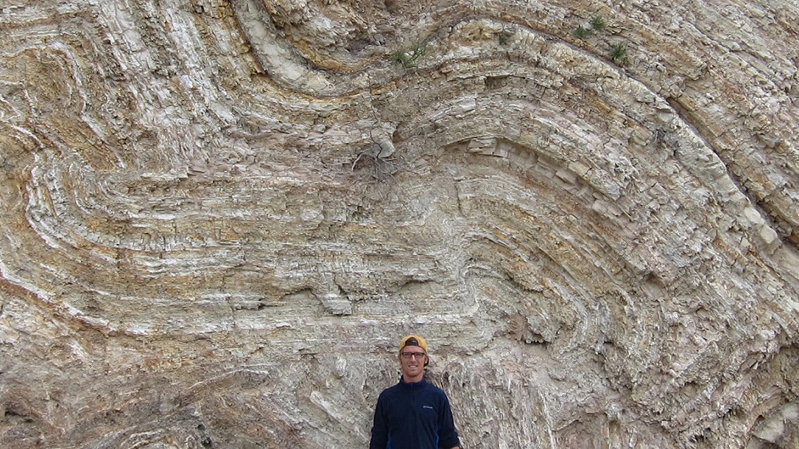 geology student posing in from of a rock formation