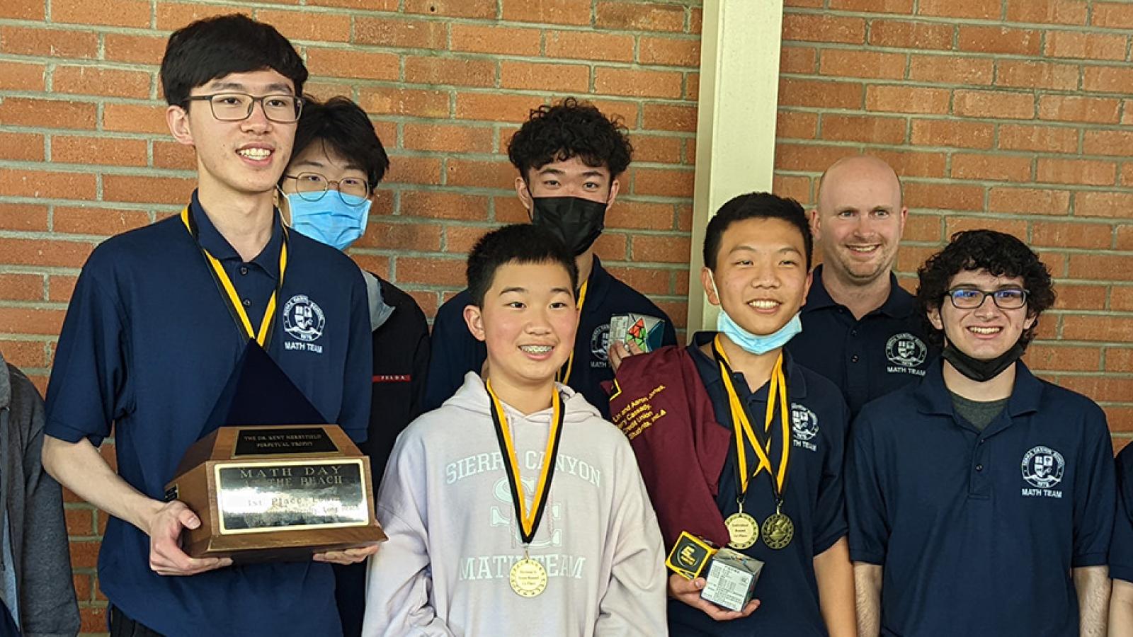 Math Day winners holding trophies and medals