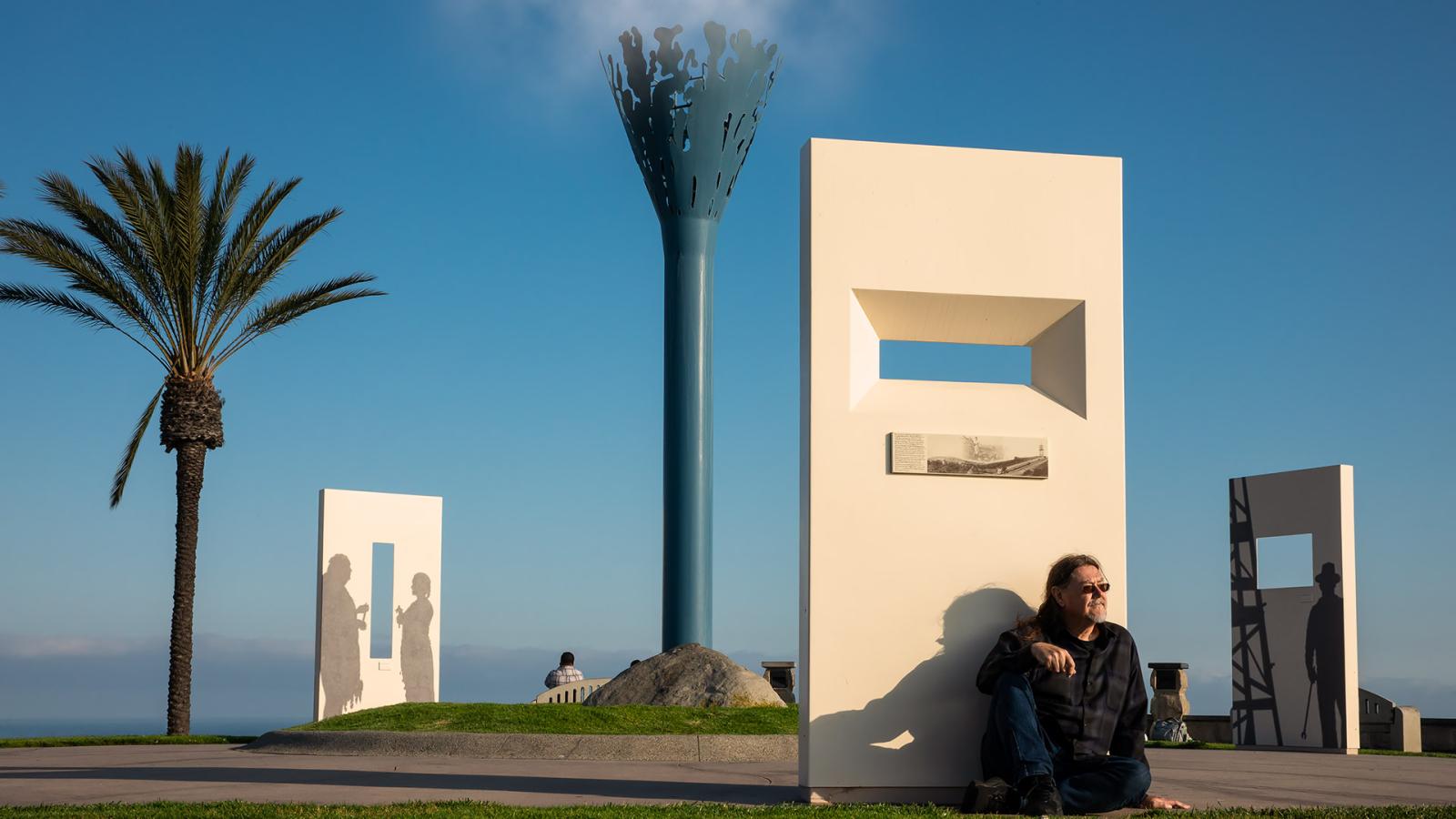 Craig Stone sitting in front of art work