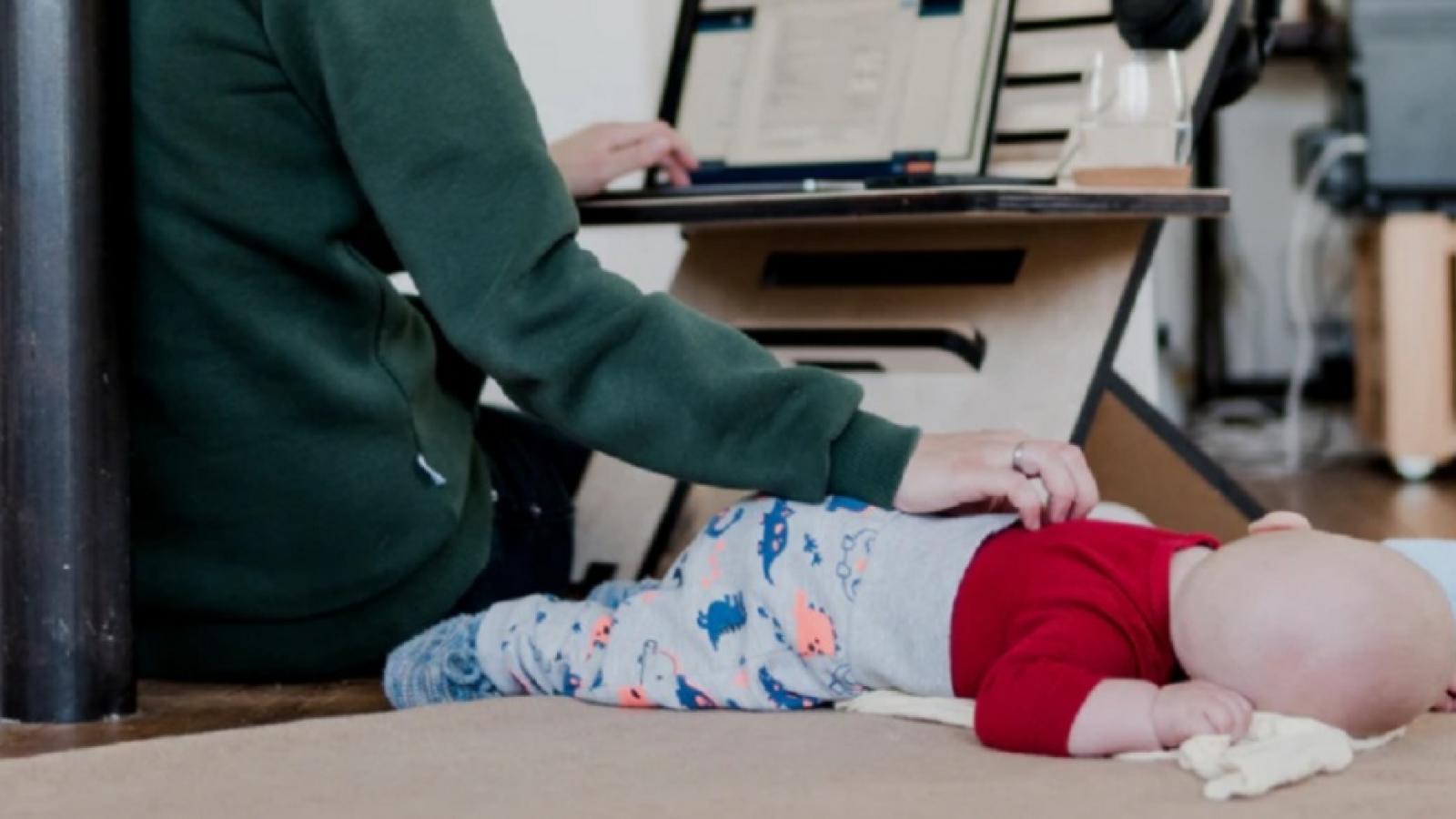 Mother working from home with a baby on the floor