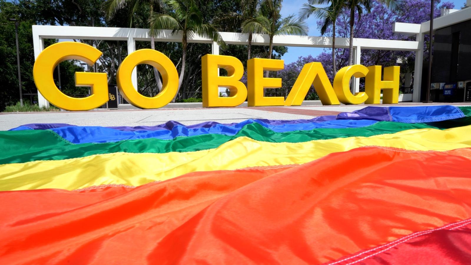Pride Flag in front of the Go Beach sign.