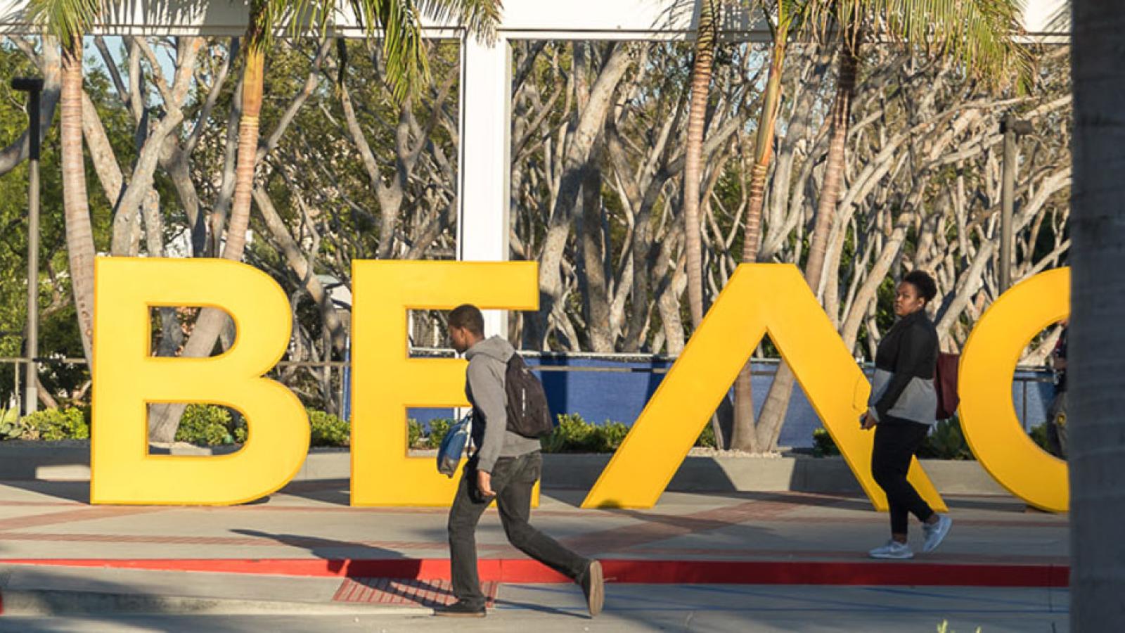 Students walk by the GO BEACH sign